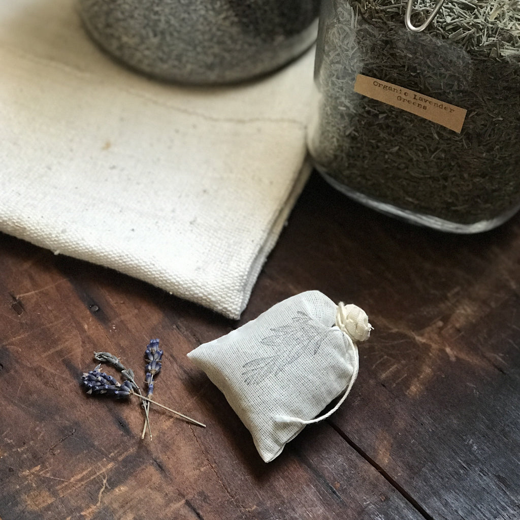 organic lavender flowers next to a cotton bag stamped with botanicals.